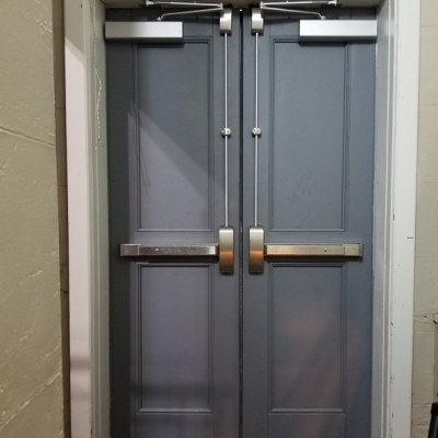 297 E 3rd St NY, NY - Pair of fire rated two (2) panel doors with stainless steel vertical panic exit devices and surface mounted door closers.