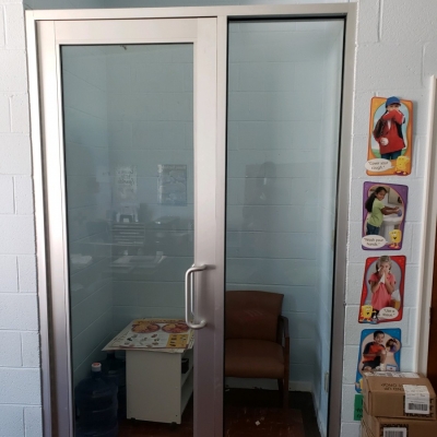 Custom made medium style clear anodized aluminum nurse room door with sidelite.