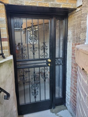 Custom made wide iron gate with side light with plexiglass, screen, key knob and deadbolt (all painted black).