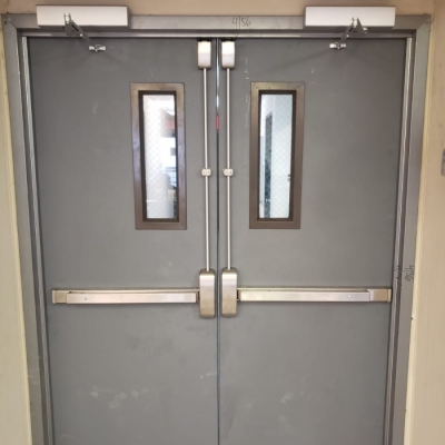 PAIR of hollow metal doors with KD steel frame, 7" x 22" vision lites and vertical panic exit devices.